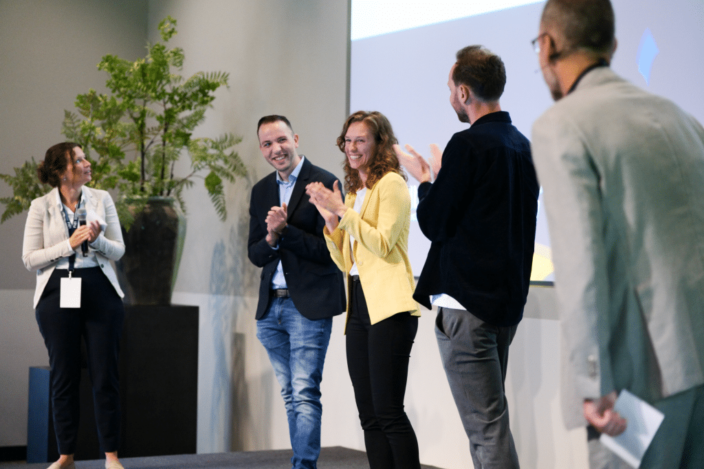 Mike Mennen, Chrystal Huberts en Joost de Boer op het podium tijdens de verkiezing Young Financial 2024